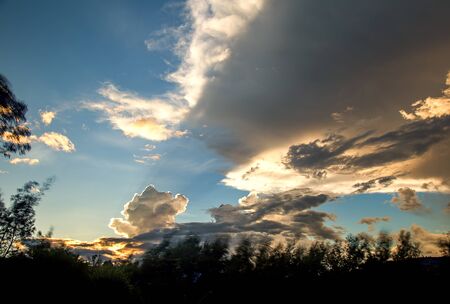 Multiple exposure of a dense cloud at the horizon casting an awesome shadow on the sky at sunset. Captured at the Andean mountains of central Colombia.の写真素材