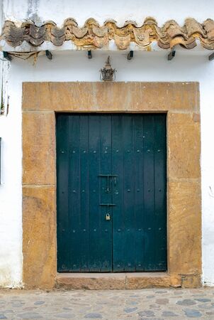 A fancy big blue old door in a street of the colonial town of Villa de Leyva, in the Andean...