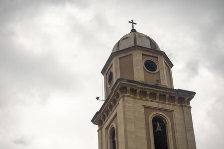 Bell tower of the colonial church of Iza, an old town in the Andean mountains of central Colombia, captured against the overcasted sky.の写真素材