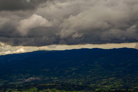 Multiple exposure of an overcasted sky over the central Andean mountains of Colombia, with the farmlands and a typical town of the region.の写真素材