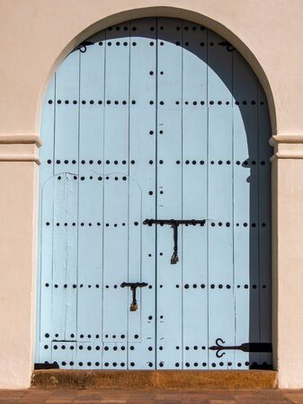 The blue colonial wooden door of church at the colonial town of Villa de Leyva in the Andean mountains of central Colombia.の写真素材