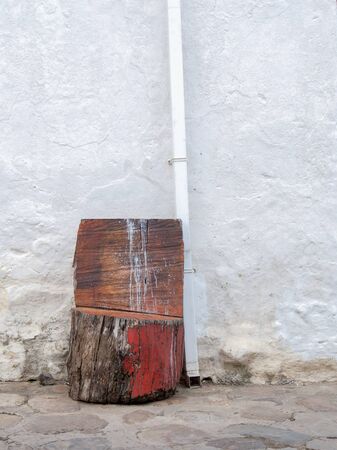A rustic chair made with a tree trunk on a street of the colonial town of Villa de Leyva, in the central mountains of the Colombian Andes.の写真素材