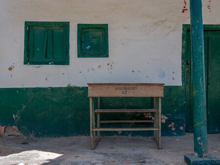 An old school desk left in front of a house at the colonial town of Chiquiza, in the Central BoyacÃ¡ Province, part of the Colombian Department of BoyacÃ¡. The text reads: Bonus 89, in Spanish.の写真素材