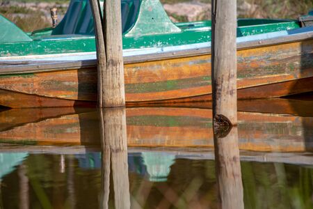 Some old boats and wooden posts on the water of the Las Coloradas lagoon, captured at sunset near the town of Gachantiva in the central department of Boyaca, Colombia.の写真素材
