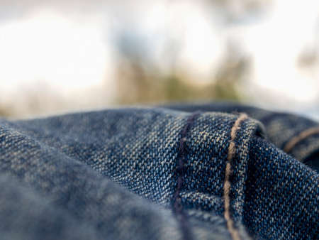 Macro photography of the folds of a pair of jeans  looking like hills against the cloudy sky.の写真素材