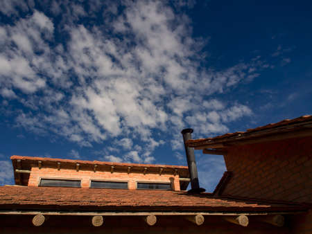 View of a country house roof against a blue sky with a cloud, captured near the colonial town of Villa de Leyva, in the central mountains of Colombia.の写真素材