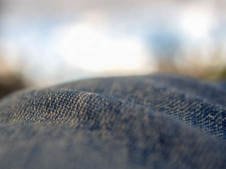 Macro photography of the folds of a pair of jeans  looking like hills against the cloudy sky.の写真素材