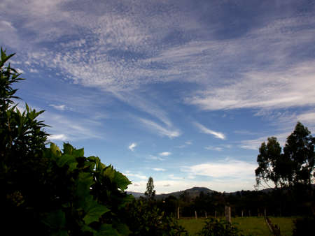 Cirrus and cirrocumulus clouds over a farmfield at morning, near the town of Villa de Leyva in central Colombia.の写真素材
