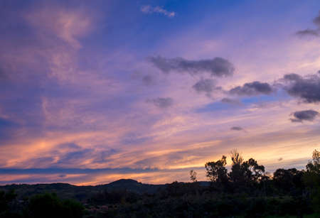 Multiple exposure composite of colorful soft clouds at west at sunrise, in the eastern Andes range in central Colombia near the colonial town of Villa de Leyva.の写真素材