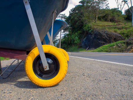 A line of wheelbarrows at the edge of a road, near the town of Moniquira in central Colombia. In the yellow tires it can be read "Do not use at high speeds" and "anti-flat tire" in Spanish.の写真素材