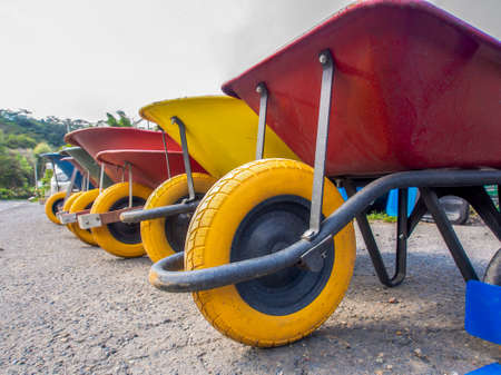 A line of wheelbarrows at the edge of a road, near the town of Moniquira in central Colombia. In the yellow tires it can be read "Do not use at high speeds" and "anti-flat tire" in Spanish.の写真素材