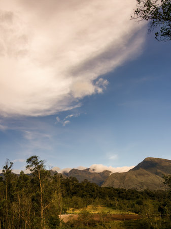 A mostly clear sky and soft clouds in the afternoon, over the farmlands in the eastern Andean mountains of central Colombia.の写真素材