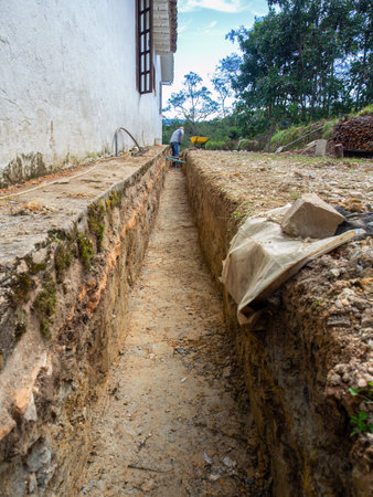 A man digging a ditch for rain water management in a farmhouse, in the eastern Andean mountains of central Colombia.の写真素材