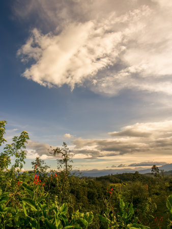 A mostly clear sky and soft clouds in the afternoon, over the farmlands in the eastern Andean mountains of central Colombia.の写真素材