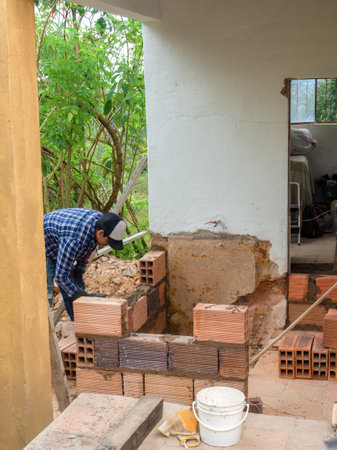 A man building a little room with hollow bricks in a farmhouse near the town of Arcabuco in the eastern Andean mountains of central Colombia.の写真素材