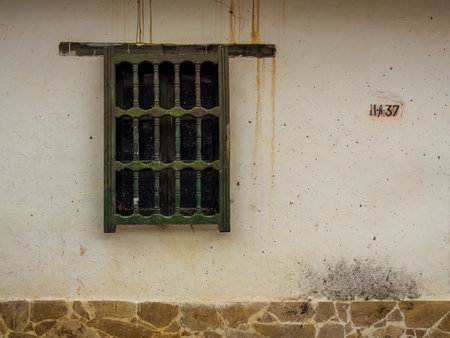 An old wooden window in a very weathered wall, in the colonial town of Villa de Leyva in central Colombia.の写真素材
