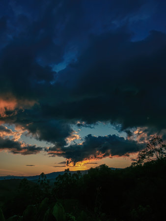 A mostly red afterglow casted on big dense clouds by the light of the sunset, over the western Andean mountains of central Colombia, near the town of Villa de Leyva.の写真素材
