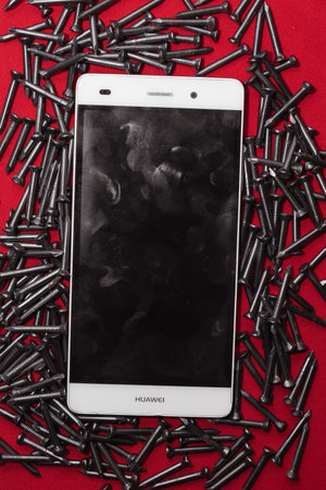 Black steel nails, arranged horizontally next to mobile phone, space for advertisingの写真素材