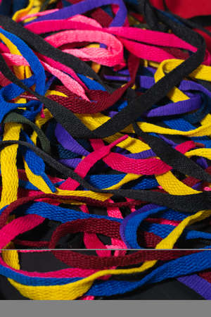 colorful shoelaces background, on black wood, messy, clutter concept, advertisementの写真素材