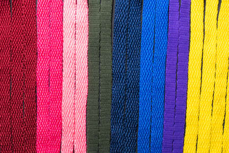 background of colored shoelaces on black wood, arranged vertically, concept of perfection, leaving space for advertising textの写真素材