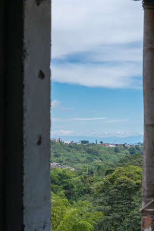 View from a window the horizon in the city of Pereira-Colombia, with the meeting of urban and rural areas, cloudy sky and warm weatherの写真素材