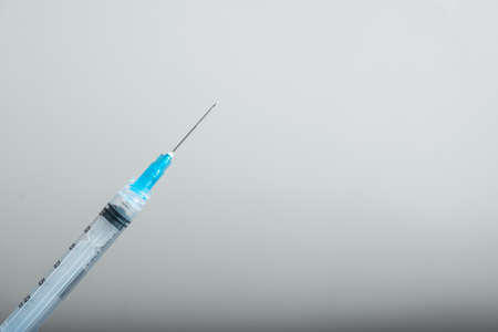 syringe ready for vaccination. coming from bottom left, vaccination and protection tools (covid-19, influenza) pandemic and health conceptの写真素材