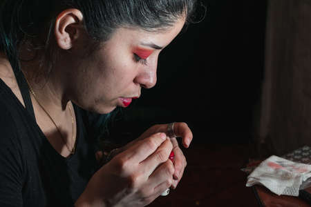 girl checking her worn lipstick. woman looking carefully at her damaged make-up, sitting in front of...