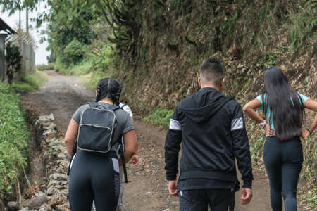 young latinos hiking through the colombian mountains, on dirt roads and desolate trails. people go hiking in the morning to exercise their bodies. exercise and health conceptの写真素材