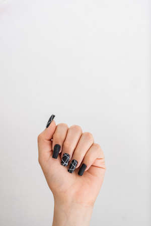 raised hand of a girl with black painted fingernails, wielding in symbol of strength, with space above to copy text. concept of freedomの写真素材