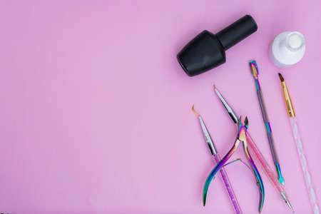 basic elements for a manicure, placed on a pink background. black and white nail polish, colored brushes, cuticle pusher and cuticle nippers items for sale and marketing in the aesthetic beauty marketの写真素材