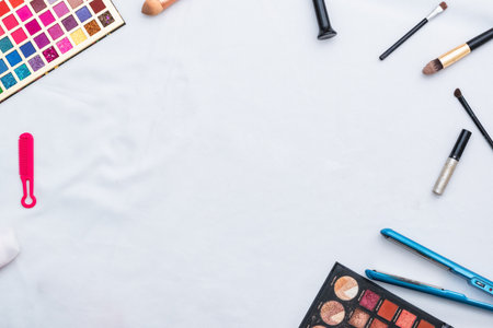 white background with surrounding make-up and accessories for personal beauty. hair straightener, eye color palette, brushes and lipsticks.の写真素材