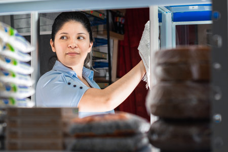 view of a young latina's face through a shelf. girl working in a colombian corner store.の写真素材