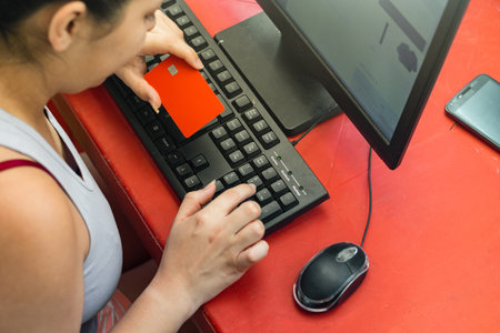 young latina woman making an online purchase from home, credit card in handの写真素材
