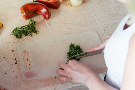 view from above of a girl chopping cilantro for saladの写真素材