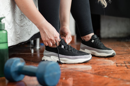 detailed shot of a woman tying her shoelaces before going out for a workoutの写真素材