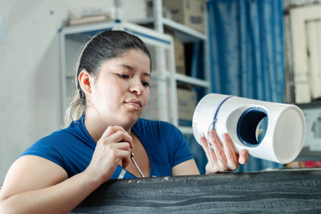 young latina woman watching attentively how an automatic mosquito catcher worksの写真素材