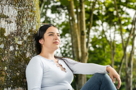 portrait of beautiful latin girl, thinking while breathing in the fresh air of natureの写真素材