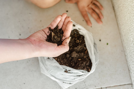 detail of a woman's hand grabbing earth from the sack to start plantingの写真素材