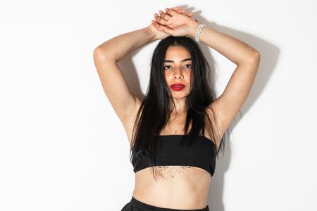 brown-skinned latina girl posing on a white background with her hands above her headの写真素材
