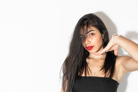 beautiful latina woman with brown skin posing on a white background, showing her chin.の写真素材