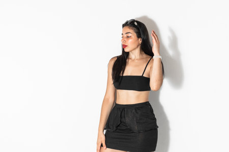 portrait of beautiful brown-skinned latina woman posing and looking sideways, on a white backgroundの写真素材