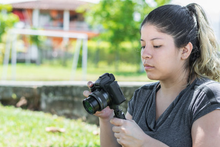 close-up of a girl blogger holding a camera in her hand with which she records her travel vlogsの写真素材
