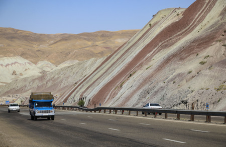 Cars driving on the highway through beautiful colorful mountains similar to eastern spices in Tabriz, Iranの写真素材