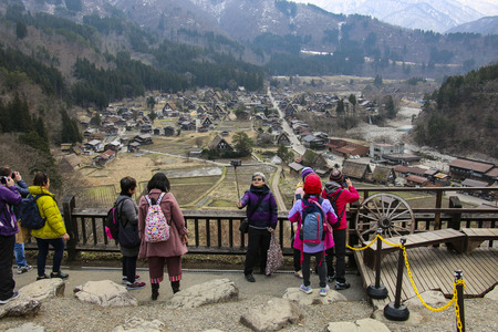 SHIRAKAWA, JAPAN- MARCH 27, 2019: Tourists on the viewing platform take a selfie on the background of a panoramic view of Shirakawa-go Village, Gifu, Japanのeditorial素材
