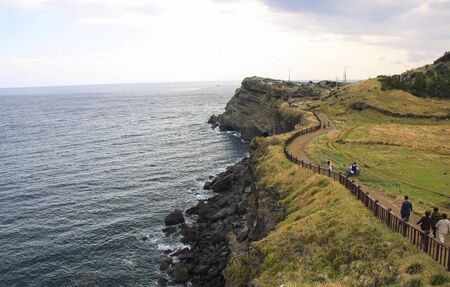 Tourists walk along beautiful pathway of Songaksan Mountain in Jeju Island, South Koreaの写真素材