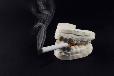 A cigarette in his mouth that harms the health of our teeth