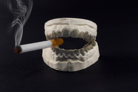 A cigarette in his mouth that harms the health of our teeth