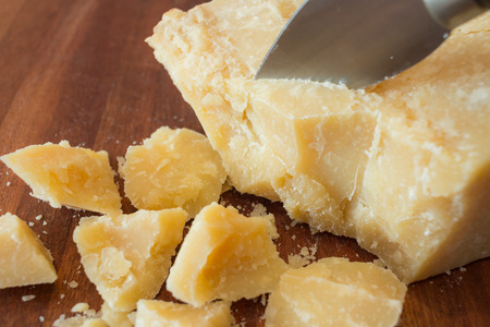 pieces of parmesan cheese on a wooden cutting boardの写真素材