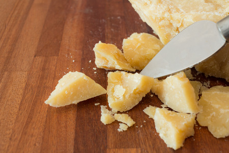pieces of parmesan cheese on a wooden cutting boardの写真素材
