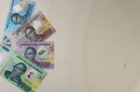 Overhead shot of Angolan Kwanzas banknotes new serie launched at the end of 2020, on wooden Table.の写真素材